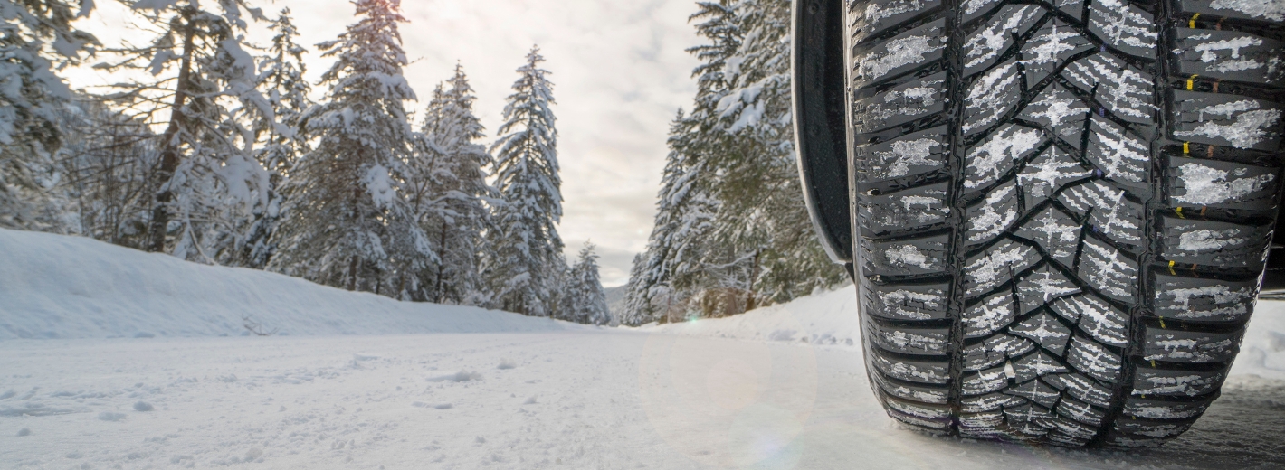 Winterreifen auf Schneefahrbahn in Wald