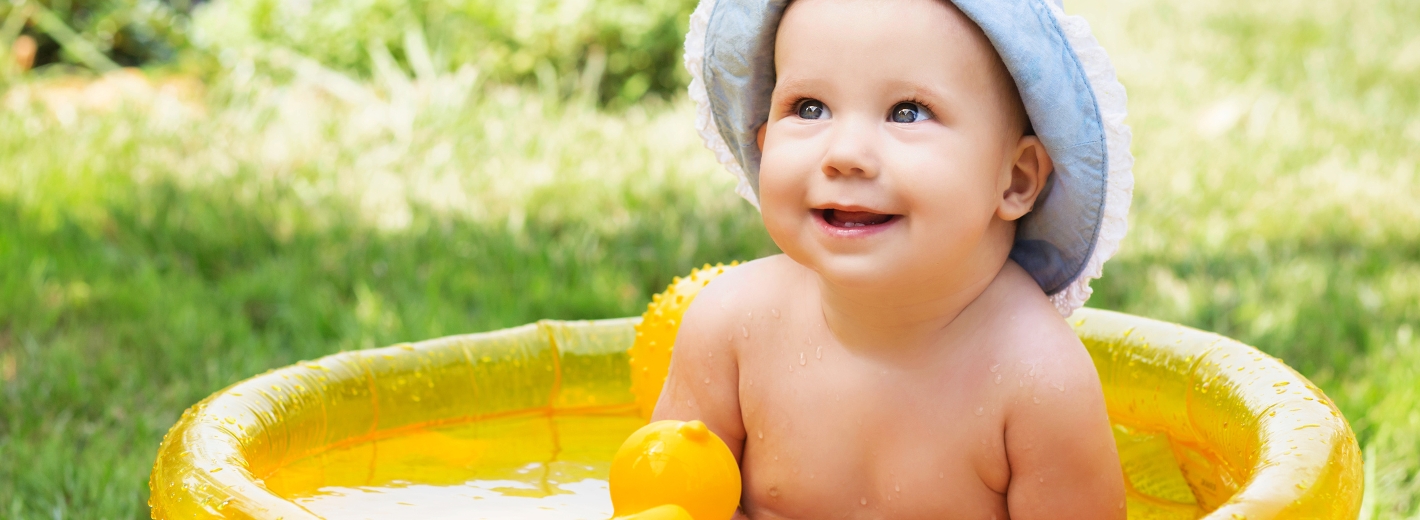 Baby sitzt in Planschbecken