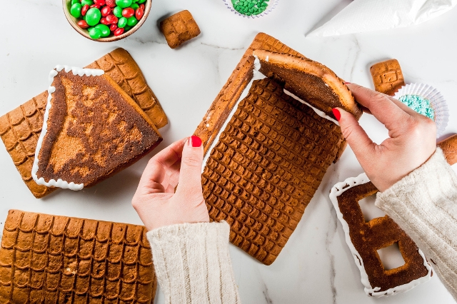 Hand hält Lebkuchenhaushälften zusammen