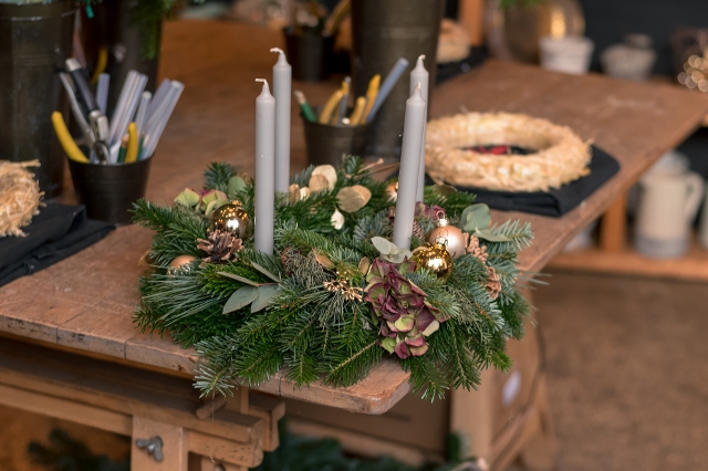 Adventkranz mit grauen Stabkerzen und unterschiedlichen Nadelzweigen