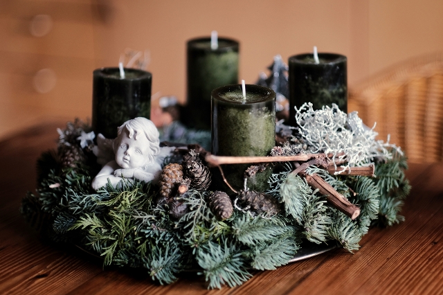 Adventkranz mit dunkelgrünen Kerzen und einer Engelsfigur