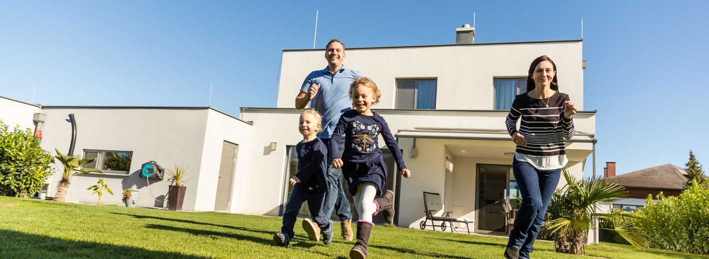Familie im Garten vor ihrem Haus