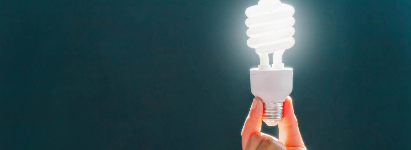 Hand hält Energiesparlampe