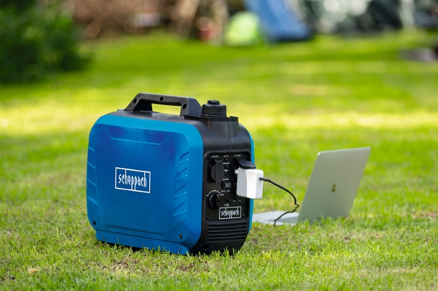 Im Garten steht ein Laptop und ist an einem Scheppach Stromerzeuger angeschlossen.