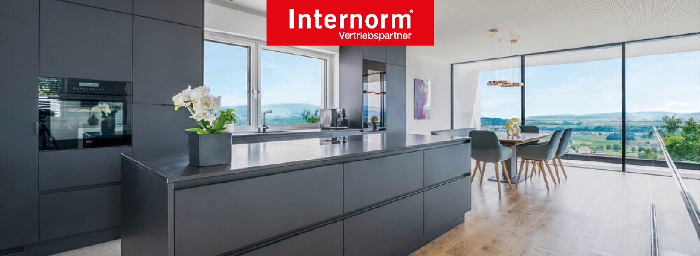 Foto von großem Wohnraum mit offener Küche und großen Fenstern