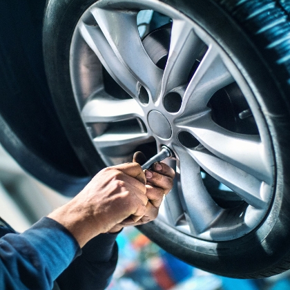 Mechaniker der einen Autoreifen wechselt