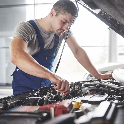 Mechaniker bei der Reparatur in der Motorhaube eines Autos