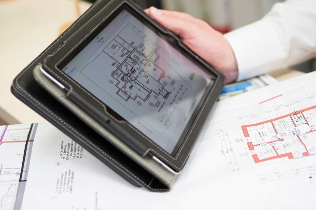 Lagerhaus Mitarbeiter der auf einem Tablet einen Bauplan präsentiert.
