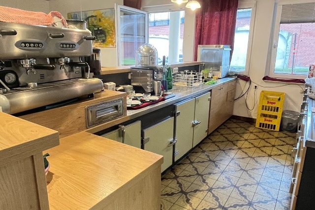Bar des Gasthauses zur Ähre in St. Pölten. Eine silberne, große Kaffeemaschine, mehrere Gläser, Getränkekisten und vorbereitetes Geschirr zum Servieren von Kaffee.
