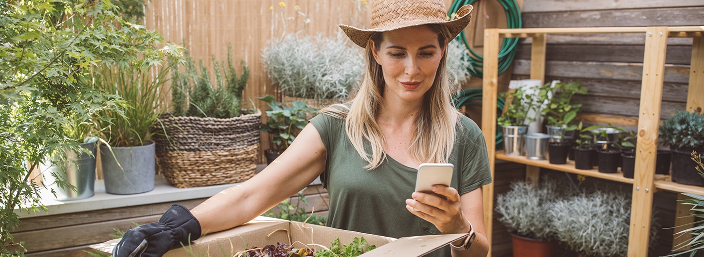 Gärtnerin mit Smartphone in der Hand