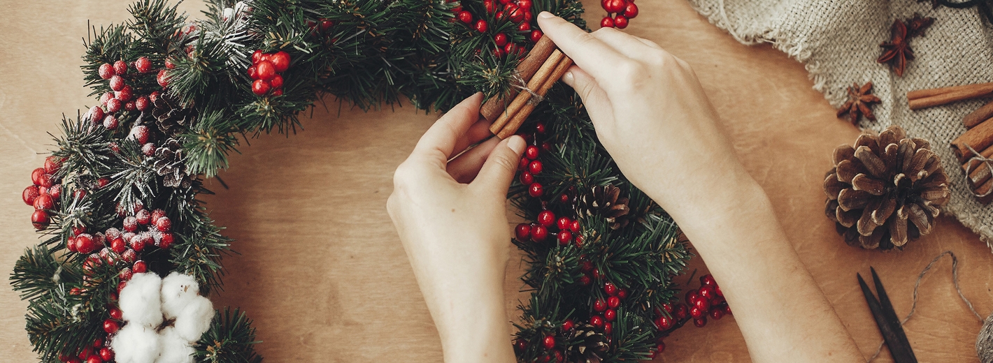 Hände die einen Adventkranz binden