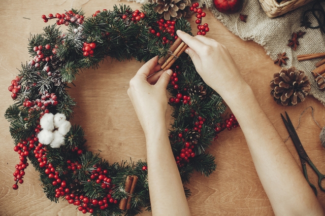 Hände die einen Adventkranz binden