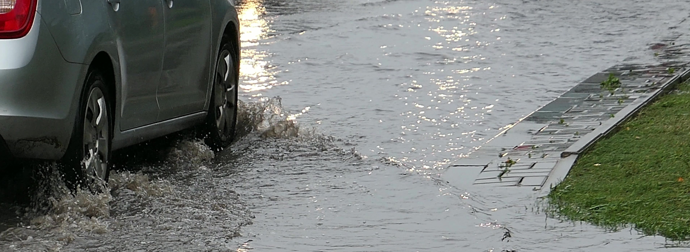 Auto fährt durch hohes Wasser