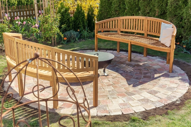 Runde Terrasse mit Pflastersteinen und Bänken