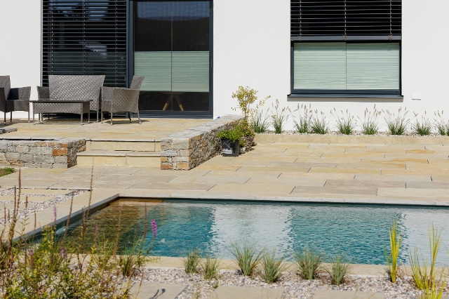 Naturstein als Bodenbelag der Terrasse um einen Pool
