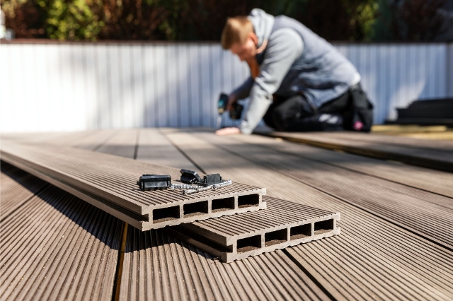 Mann baut Terrasse mit WPC-Dielen