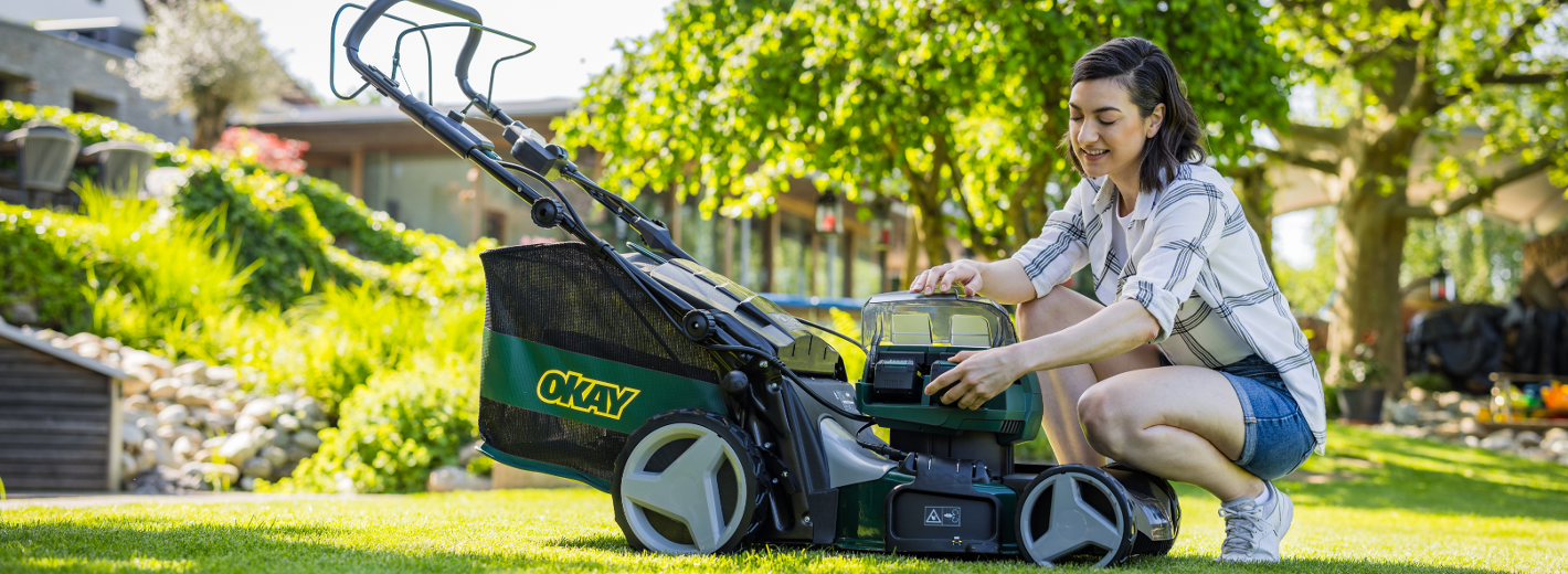 Frau mit OKAY Rasenmäher im Garten