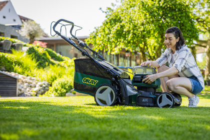 Frau mit OKAY Rasenmäher im Garten