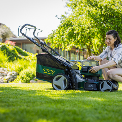 Frau mit OKAY Rasenmäher im Garten