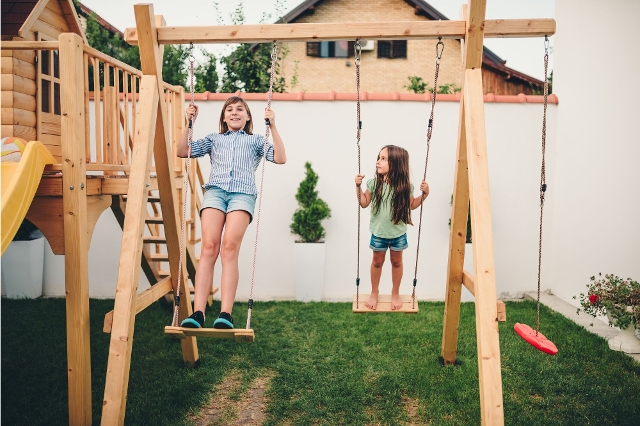 Kinder schaukeln im Garten