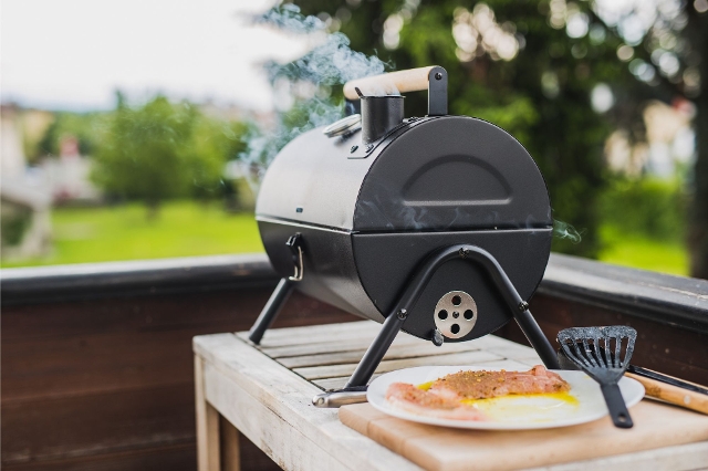 Fleisch wird in einem Smoker auf der Terrasse langsam gegart