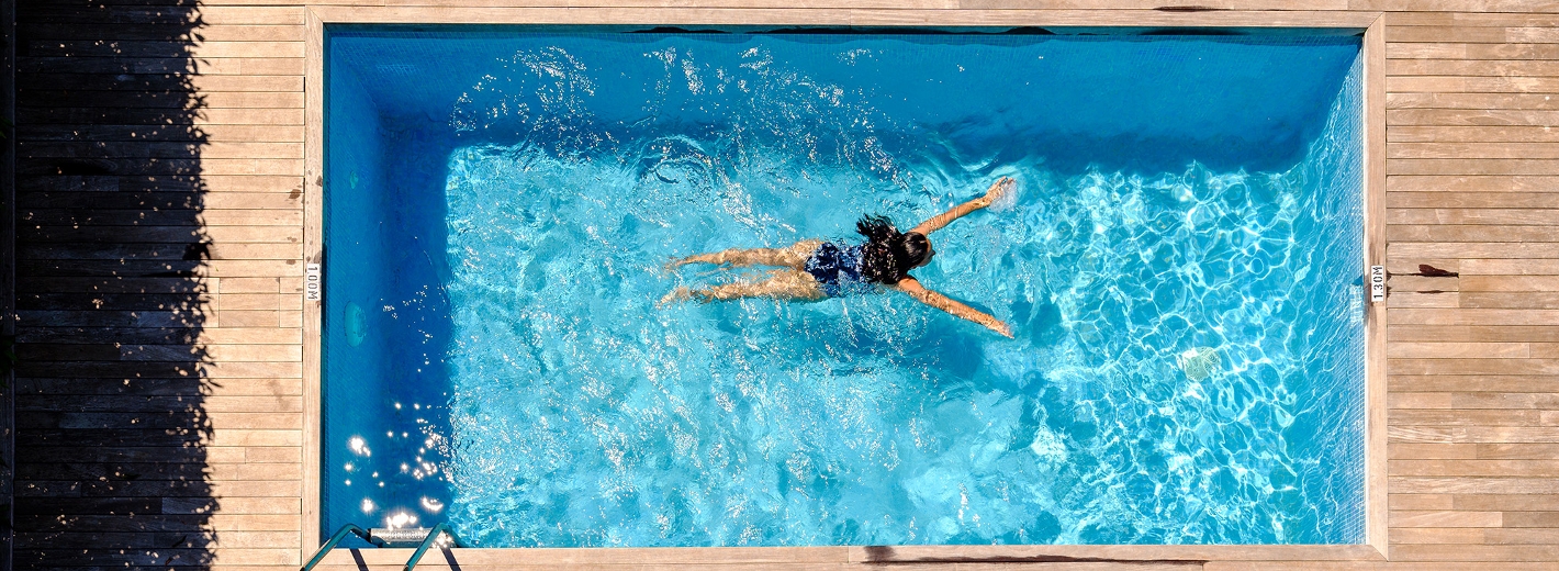 Frau schwimmt in Einbaupool im Garten