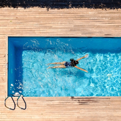 Frau schwimmt in Einbaupool im Garten