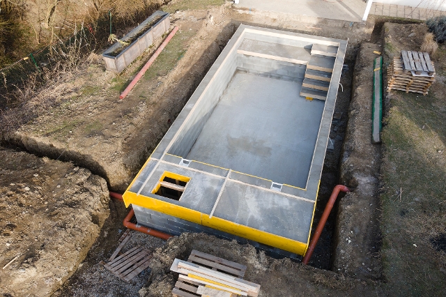 Selbstgebauter Pool wird im Garten aufgebaut