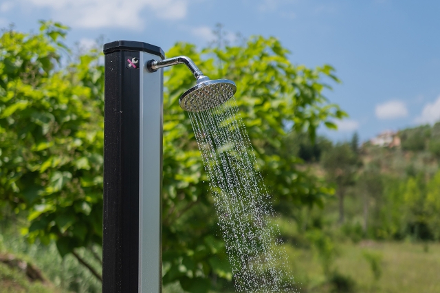 Eine schwarze Solardusche im Garten