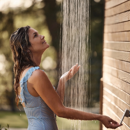 Frau duscht in Gartendusche