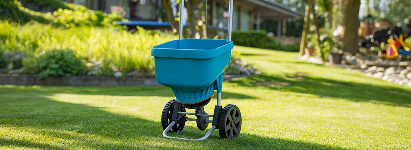 GARDENA Streuwagen steht am Rasen