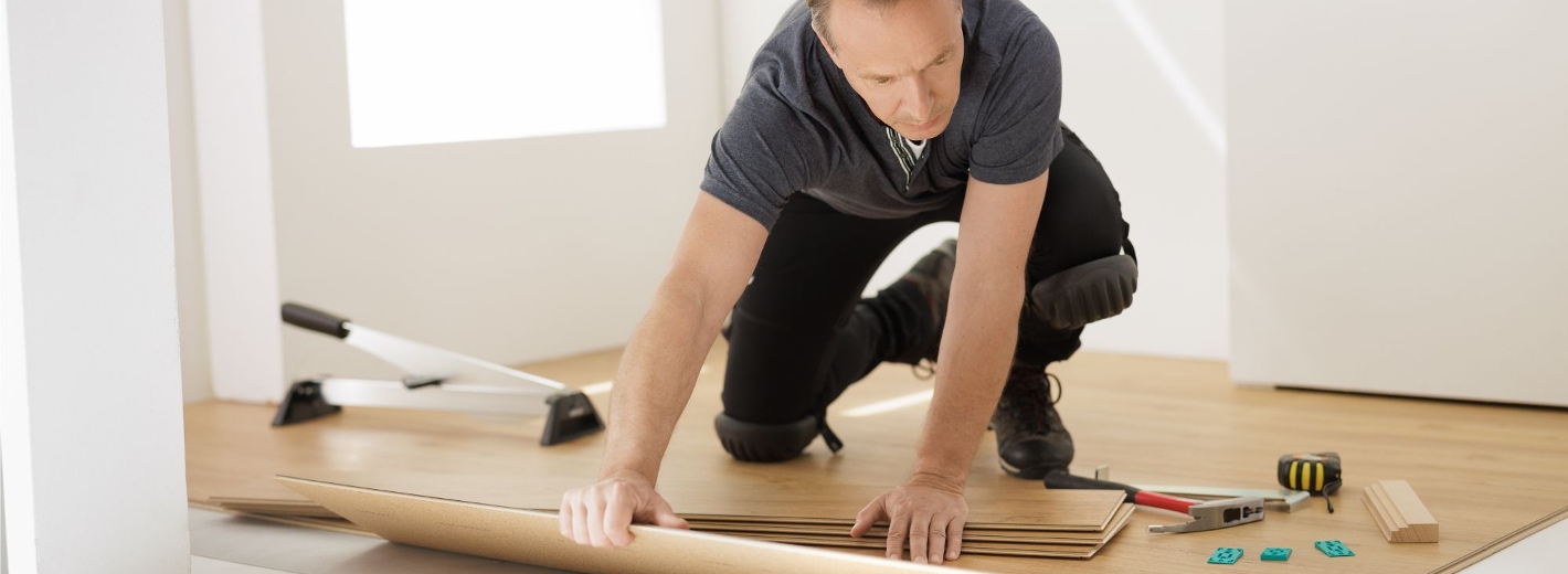 Handwerker verlegt den Boden im Haus