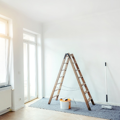 Frisch gestrichenes Zimmer mit Leiter und Malerzubehör