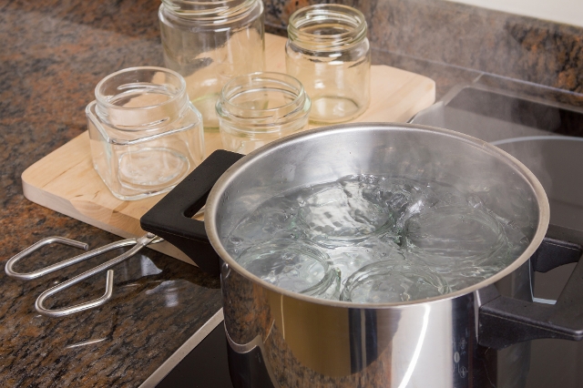 Gläser sind in einem Kochtopf mit Wasser zum Sterilisieren