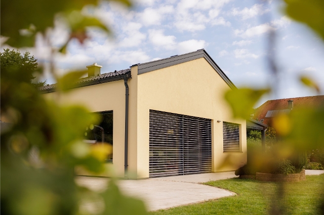 Haus mit Rolladen im Sommer