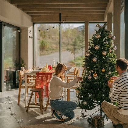 Junges Paar schmückt Christbaum vor Heiligabend
