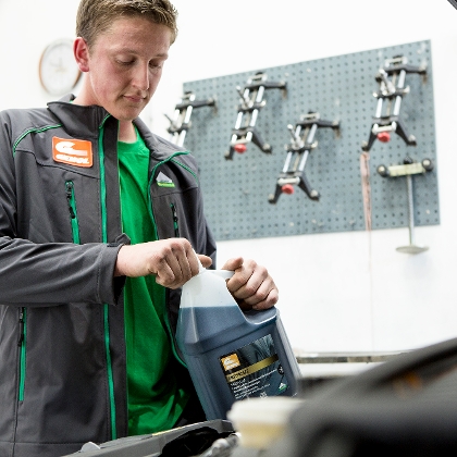 Mechaniker füllt Kühlerfrostschutz von Genol nach