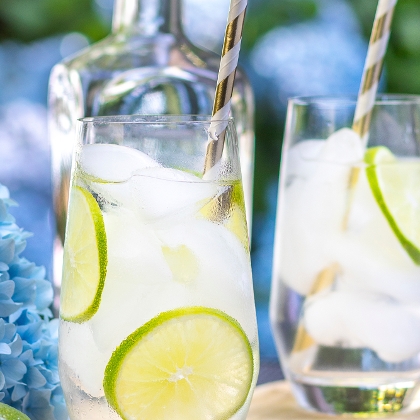 Eisgekühlte Getränke mit Limettenscheiben und Strohhalm