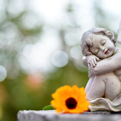 Engelsfigur und Blume auf Grab