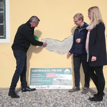Lagerhausmitarbeiter begutachtet gemeinsam mit Kunden die sanierungsbedürftigen Stellen an der Fassade des Hauses