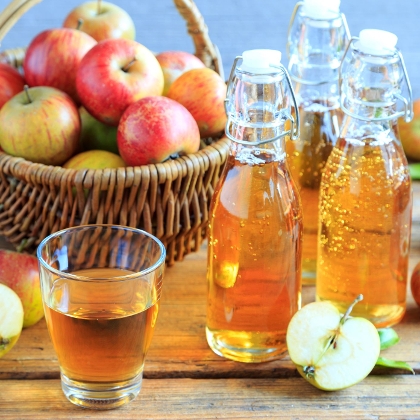Apfel und Apfelsaftflaschen auf einem Tisch