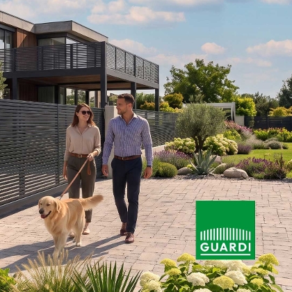 Paar mit Hund vor modernem Haus mit Guardi Zaun