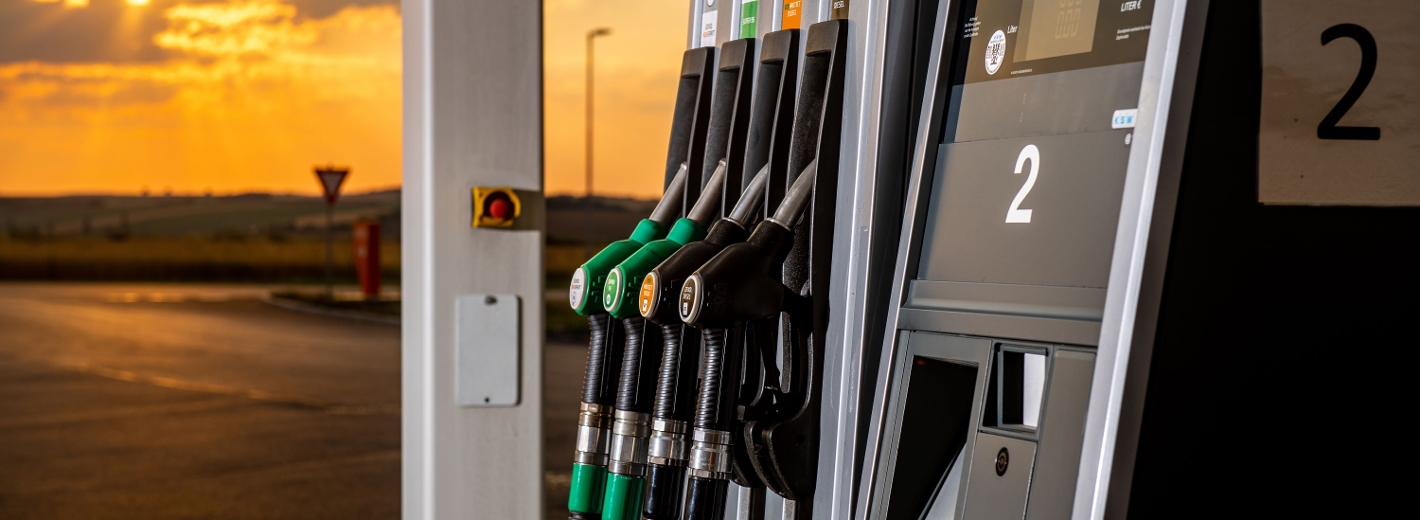 Genol Tankstelle mit Zapfsäule bei Sonnenuntergang.